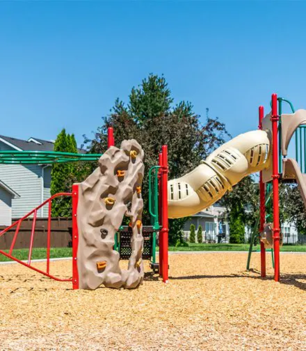 A child is playing on the slide at a playground.