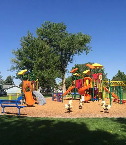 A playground with many different colored slides and swings.