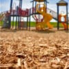 Playground mulch under colorful playset.